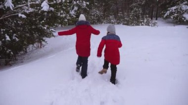 Çam kış kar parkı snowdrifts ile çalışan genç kızlar. Çocuk kışın yakalamak oyun. Noel tatili. Çocuk oyunları doğada