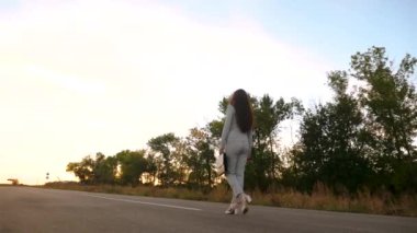 Acele bir iş toplantısı için kadın avukat. iş kadını elinde siyah evrak çantası taşıyor. kadın pantolon ve ceket ve beyaz yüksek topuklu ayakkabı giyen şehir dışında asfalt boyunca yürür