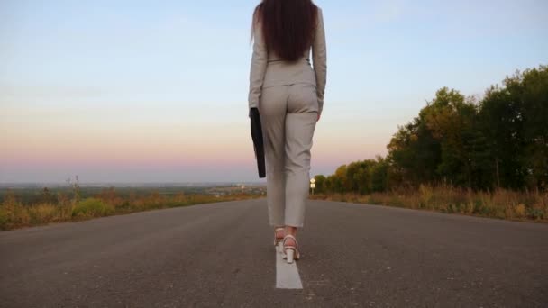 Female lawyer goes on way to business meeting. business woman carries black briefcase with documents in her left hand, view from the back — Stock Video