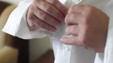 Adam işadamı üzerinde beyaz gömlek düğmeleri elleriyle kadar düğmelerini sabah koyar. Kavram iş işçisi. Yakın çekim.