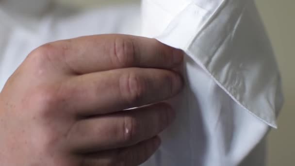 Homem empresário veste camisa branca de manhã, abotoando os botões com as mãos. Trabalhador empresarial de conceito. Close-up — Vídeo de Stock