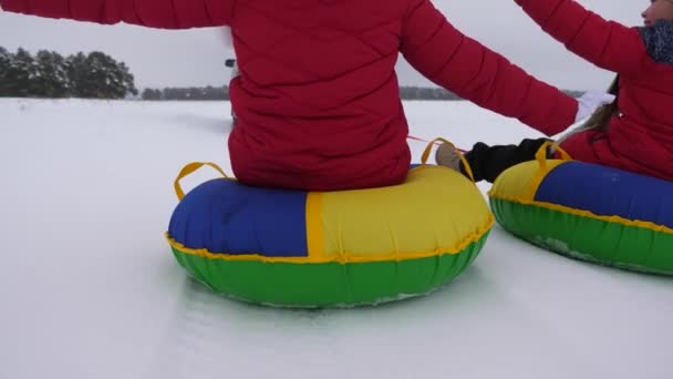 Niños felices montando montañas nevadas, enderezando sus brazos en vuelo y riendo. Feliz infancia en invierno en trineo. Vacaciones de Navidad — Vídeos de Stock