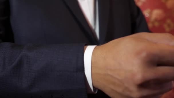 Чоловік у костюмі регулює рукав білої сорочки . — стокове відео