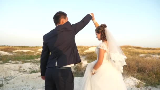 Happy groom dancing with a beautiful bride. Dance of lovers on exit wedding marriage ceremony. Happy young men laugh and smile with each other. Loving couple creates new and strong family — Stockvideo