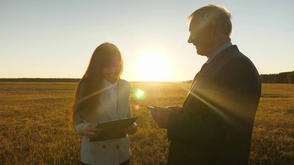 Geschäftsmann mit Aktentasche und Geschäftsfrau mit Tablet verhandeln bei Sonnenuntergang und lachen. Geschäftstreffen mit Arbeitspartner — Stockfoto