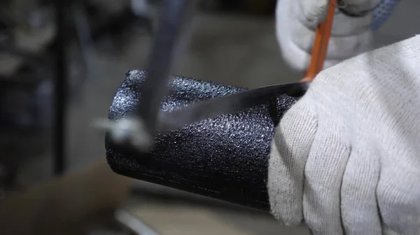 Worker saws pipe with a hacksaw — Stock Photo, Image