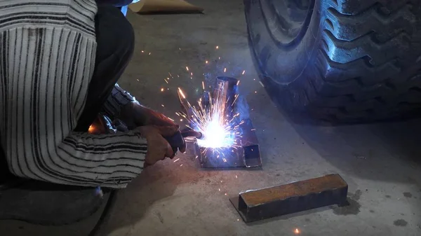 Welder connects metal parts to complex structures using electric welding. colorful sparks fly to the side — Stock Photo, Image