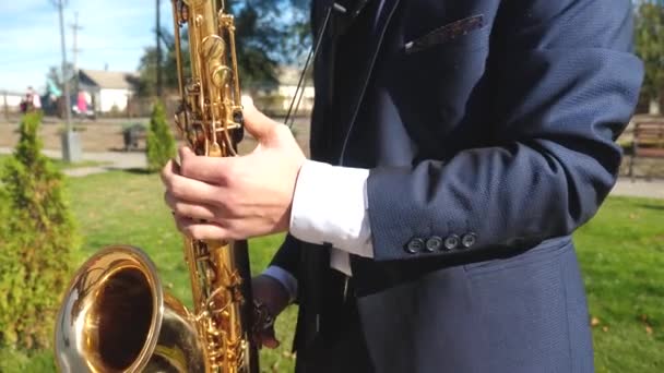 Um homem a tocar saxofone jazz. Saxofonista em jaqueta jogar no saxofone dourado. Desempenho ao vivo . — Vídeo de Stock