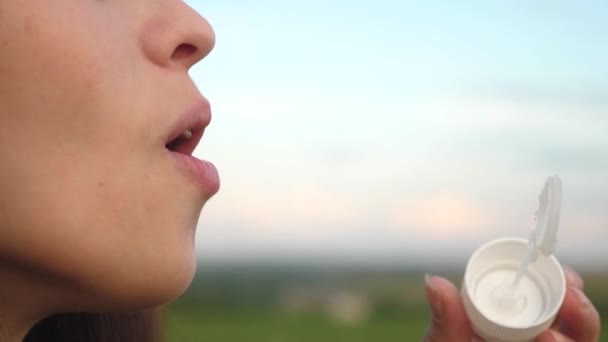 Meisje blaast transparante zeepbellen en lacht. Close-up. Slow-motion. vlucht van mooie zeepbellen in de lucht. — Stockvideo