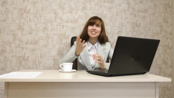 Mädchen im Büro am Schreibtisch, die am Computer arbeitet und spricht. Jungunternehmerin kommuniziert mit Kunden. Geschäftsfrau arbeitet in ihrem Büro. — Stockvideo