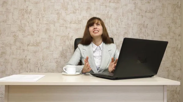 Chica en la oficina en el escritorio trabajando en el ordenador y hablando. joven empresaria se comunica con el cliente. mujer de negocios que trabaja en su oficina . — Foto de Stock