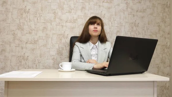 Fille au bureau au bureau travaillant à l'ordinateur et parlant. jeune entrepreneure communique avec le client. femme d'affaires travaillant dans son bureau . — Photo