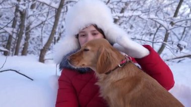 köpek kız yüz yalıyor. Güzel kız gülümsüyor, sevgili köpek kış aylarında parkta okşamalarla. av köpeği kızla kışın Ormanda yürür. köpek hostes kisses.
