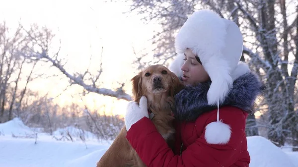 Güzel kız gülümsüyor, sevgili köpek kış aylarında parkta okşamalarla. kız bir av köpeği ile kışın Ormanda yürür. köpek hostes kisses. — Stok fotoğraf