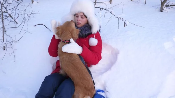 Schöne Mädchen und Hund spielen in Schneewehen. Kind mit Jagdhund geht im Winter im Wald spazieren. Herrchen streichelt ihren geliebten Hund im Park. — Stockfoto