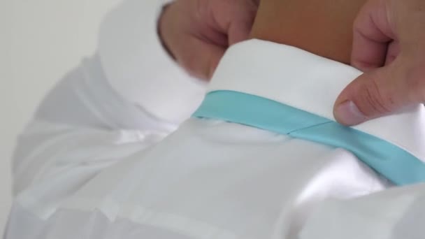 Hombre de negocios se pone corbata azul con las manos a camisa blanca por la mañana va a trabajar. Concepto de empleado de negocios. Código de vestimenta. Primer plano — Vídeo de stock