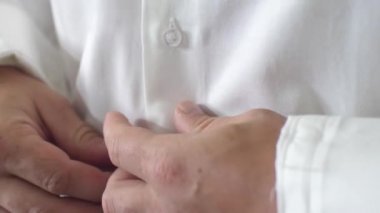 Adam işadamı üzerinde beyaz gömlek düğmeleri elleriyle kadar düğmelerini sabah koyar. Kavram iş işçisi. Yakın çekim