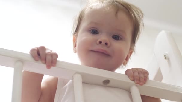 Kleines Kind steht auf den Füßen im Babybett. — Stockvideo