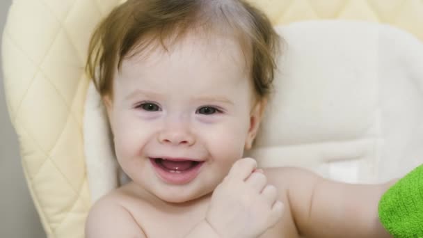 Baby smiles sitting on children chair. — Stock Video