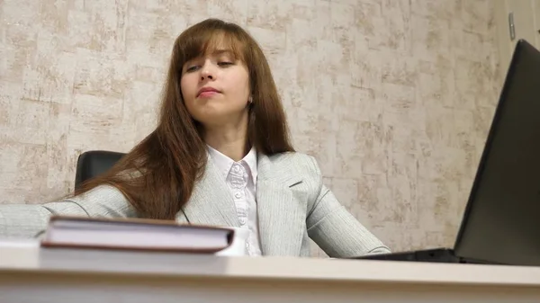 Mulher de negócios bonita sentada na cadeira no escritório e trabalhando on-line no laptop e com documentos em papel. mulher jovem empresária trabalha no computador e leva uma conversa de negócios . — Fotografia de Stock