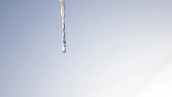 滴水的冰柱。融化的冰柱, 在蓝天的映衬下。特写。春天滴. — 图库照片