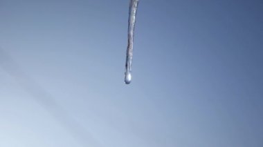 Buz sarkıtları damlama. Mavi gökyüzü karşı eriyen buz sarkıtları. closeup bahar bırakır. Ağır çekim