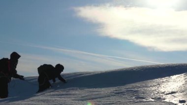 turistlerin kışın birlikte zorluklar üstesinden kar üzerinden yürüyen takım olarak çalışır. Üç Alpenists Dağı'nda halat tırmanmaya. Siluetleri yolcuları kendi zafer için güçlü bir rüzgar buz üzerinde ayağa kalkın.
