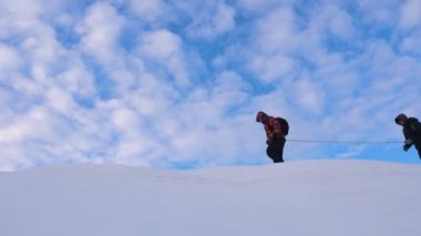 dağcıların birlikte arkadaş karlı sırt boyunca sonra gidin. takım kışın gezginlerin dağın tepesine git. Kışın iyi koordineli çalışması turizm