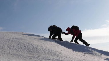 dağcılar bir karlı dağın tepesine tırmanmaya el içinde el. Kışın gezginlerin takımı zorlukların üstesinden amaçları için gidin. iyi koordineli çalışması turizm.