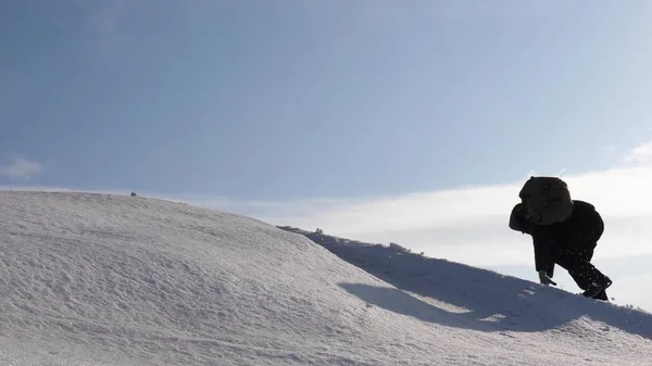 Hegymászók kéz a kéz mászni egy havas hegy tetején. a csapat a téli utazók megy céljuk a nehézségek leküzdésére. turizmus jól összehangolt csapatmunka. — Stock Fotó