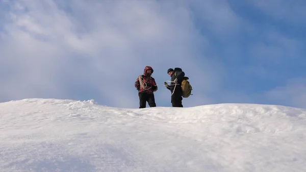 Alpenistas equipe no inverno estão se preparando para descer na corda da montanha. Os viajantes descem por corda de uma colina nevada. trabalho de equipa bem coordenado no turismo de Inverno . — Fotografia de Stock