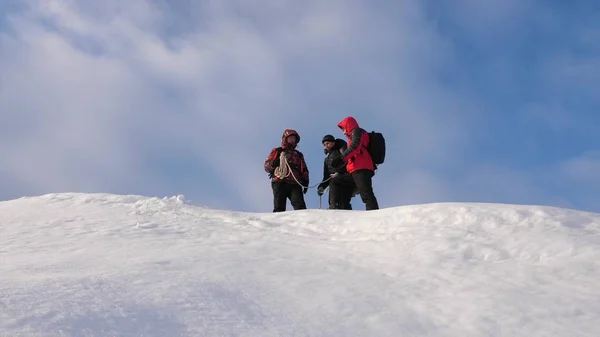 Alpenistas equipe no inverno estão se preparando para descer na corda da montanha. Os viajantes descem por corda de uma colina nevada. trabalho de equipa bem coordenado no turismo de Inverno . — Fotografia de Stock