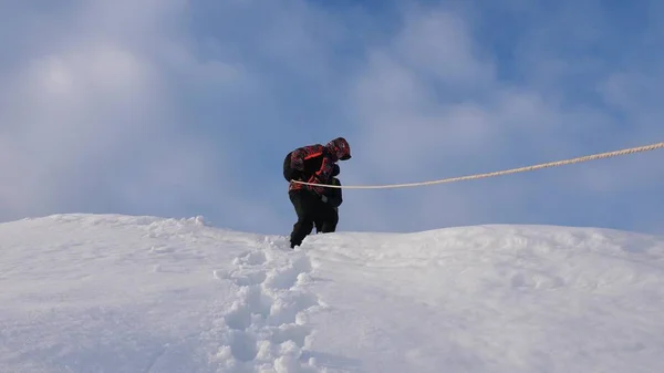 Podróżujący zejść przez liny z snowy wzgórza. Alpinistów zespołu w zimie dół liny z góry. turystyki dobrze skoordynowanej pracy zespołowej w zimie — Zdjęcie stockowe