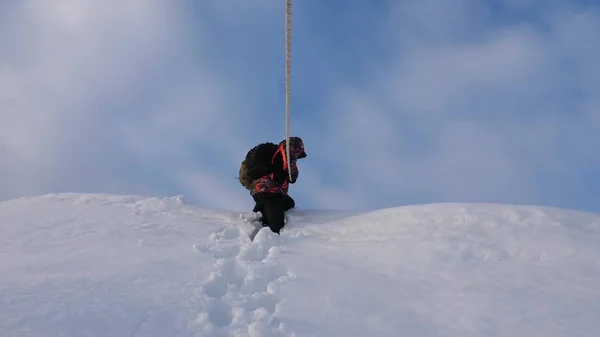 Yolcuları ip tarafından karlı tepeden inerler. Alpinists dağın İpten aşağı kış takımı. Kışın iyi koordineli çalışması turizm — Stok fotoğraf