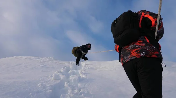 Podróżujący zejść przez liny z snowy wzgórza. Alpinistów zespołu w zimie dół liny z góry. turystyki dobrze skoordynowanej pracy zespołowej w zimie — Zdjęcie stockowe