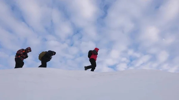 Csapatmunka az emberek a nehéz körülmények között. Télen hegymászók csapat megy a hegy tetején. Utazó kövesse egy másik mentén havas ridge. téli turizmus jól összehangolt csapatmunka — Stock Fotó