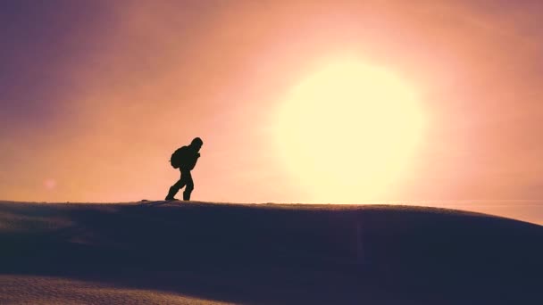 Путешественники зимой отправляются на снежный хребет, преодолевая трудности в лучах желтого заката. слаженная командная работа в зимнем туризме. альпинисты проходят через снег на вершине голома . — стоковое видео