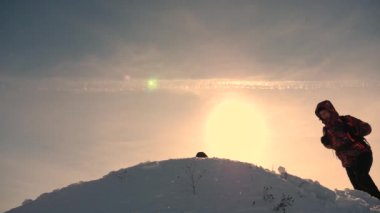 Takım çalışması ve zafer. Turistler karlı tepeye gelin ve zemin sarı bir günbatımı karşı zafer adlı sevinirler. ekip çalışması zor koşullarda insan.