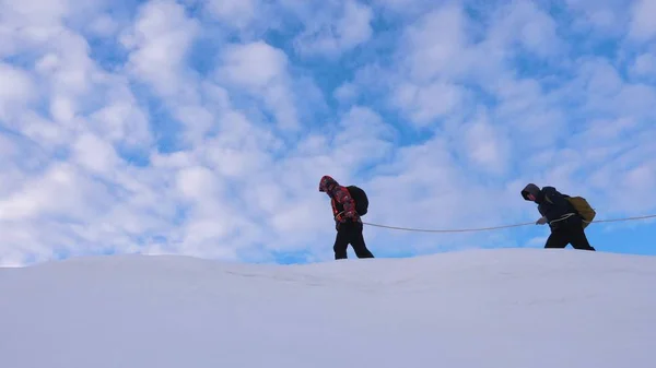 Dağcıların birlikte arkadaş karlı sırt boyunca sonra gidin. takım kışın gezginlerin dağın tepesine git. Kışın iyi koordineli çalışması turizm — Stok fotoğraf
