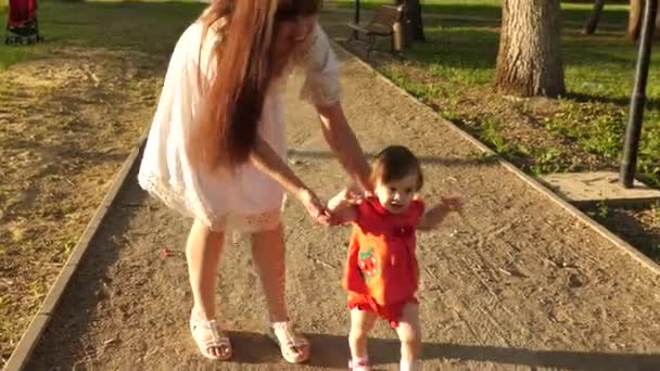 Máma a malá dcerka chodí na jaře po pěšině. v létě šťastnou rodinnou chůzi v parku. Týmová práce. koncept šťastného dětství. — Stock video