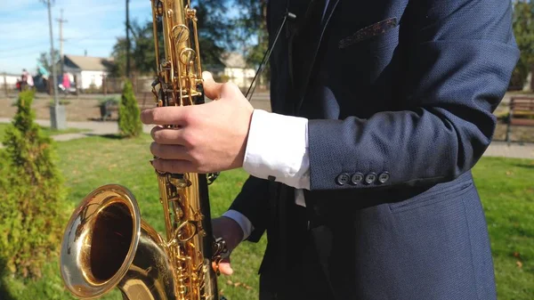 En man som spelar saxofon jazzmusik. Saxofonist i middag jacka spela på gyllene saxofon. Liveframträdande. — Stockfoto