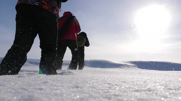 Trabajo en equipo y victoria. tres turistas alpinistas se siguen en el desierto nevado. equipo de empresarios van a la victoria y el éxito. Trabajo en equipo de empresarios . —  Fotos de Stock