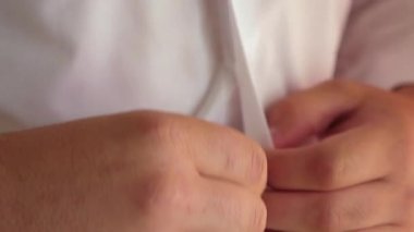 Erkekler bir düğme forması takılır. yakın çekim. işadamı beyaz forması koyar. ofis çalışanı sabah giyinmiş. adam iş için giyinmiş alır .