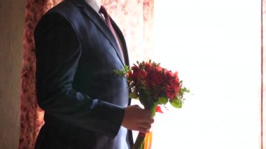 güzel çiçekler elinde bir adam onun sevgili kadın için bir hediye. güzel bir ceket ve Beyaz gömlekli adam elinde kırmızı gül buketi. çiçeklerle damat