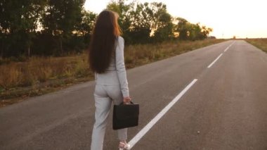 Seksi iş kadını yolda yürüyen uzun bacaklı. yakın çekim. iş kadını elinde siyah bir evrak çantası ile yolda yürüyor.