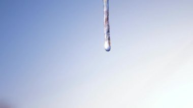 Mavi gökyüzüne karşı eriyen buz sarkıtları. closeup damlama buz sarkıtları. Bahar damla.