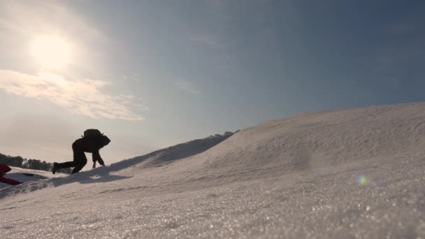 太陽の明るい光の丘の上北極圏に出張。チームワークを獲得する欲望。登山者は、アラスカの雪の山の上に登る。スポーツ観光のシベリアの概念. — ストック動画