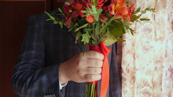 Güzel çiçekler ile iş adamı. güzel bir kırmızı kravat ve beyaz gömlek ceketli adam elinde kırmızı gül buketi. yakın çekim. — Stok fotoğraf