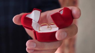 onun sevgili kadın için takı. damat onun altın alyans el kutusunda tutar. portre. Hediyelik altın dekorasyon.