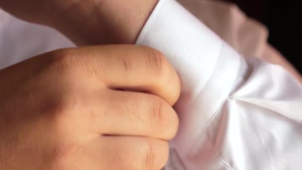 Uomini bottone un bottone sulla manica di una camicia bianca. primo piano. L'uomo d'affari si mette la camicia bianca. l'impiegato si veste la mattina. un uomo si veste per il lavoro  . — Video Stock